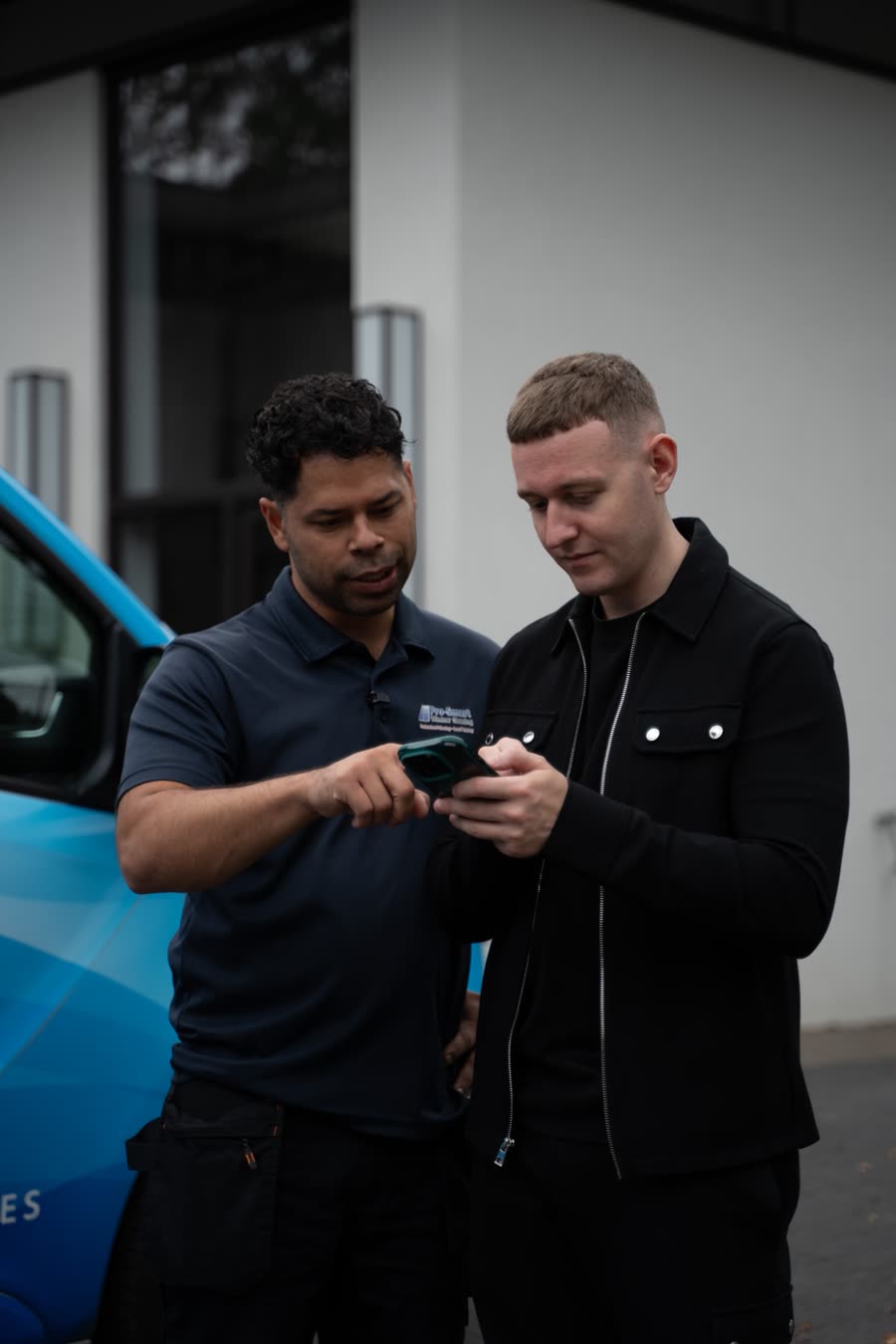 Louie and the client checking footage on a phone